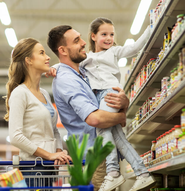 Familia comprando en supermercado. Papá, mamá e hija. Tiempo en familia.
